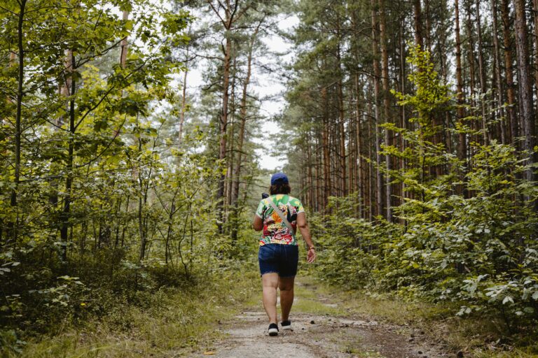 A person walking through a forest path in Saxony, Germany, enjoying a summer hike.