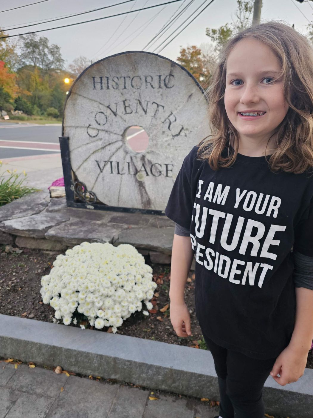 Adeline by the Historic Coventry Village millstone sign