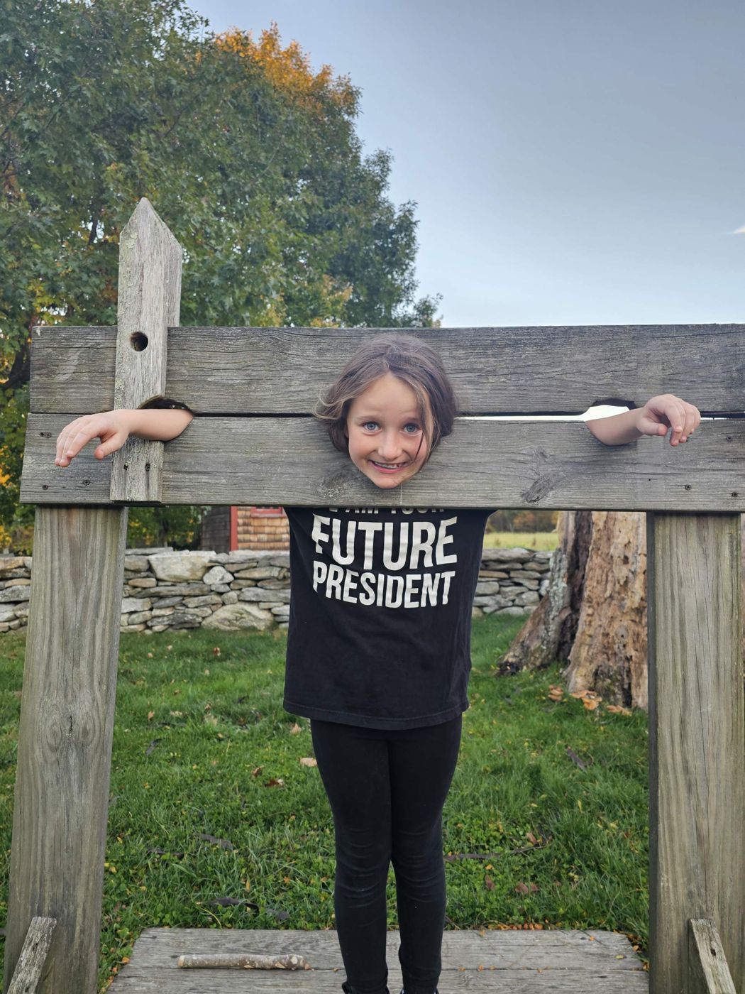 Adeline grinning in a set of colonial stocks