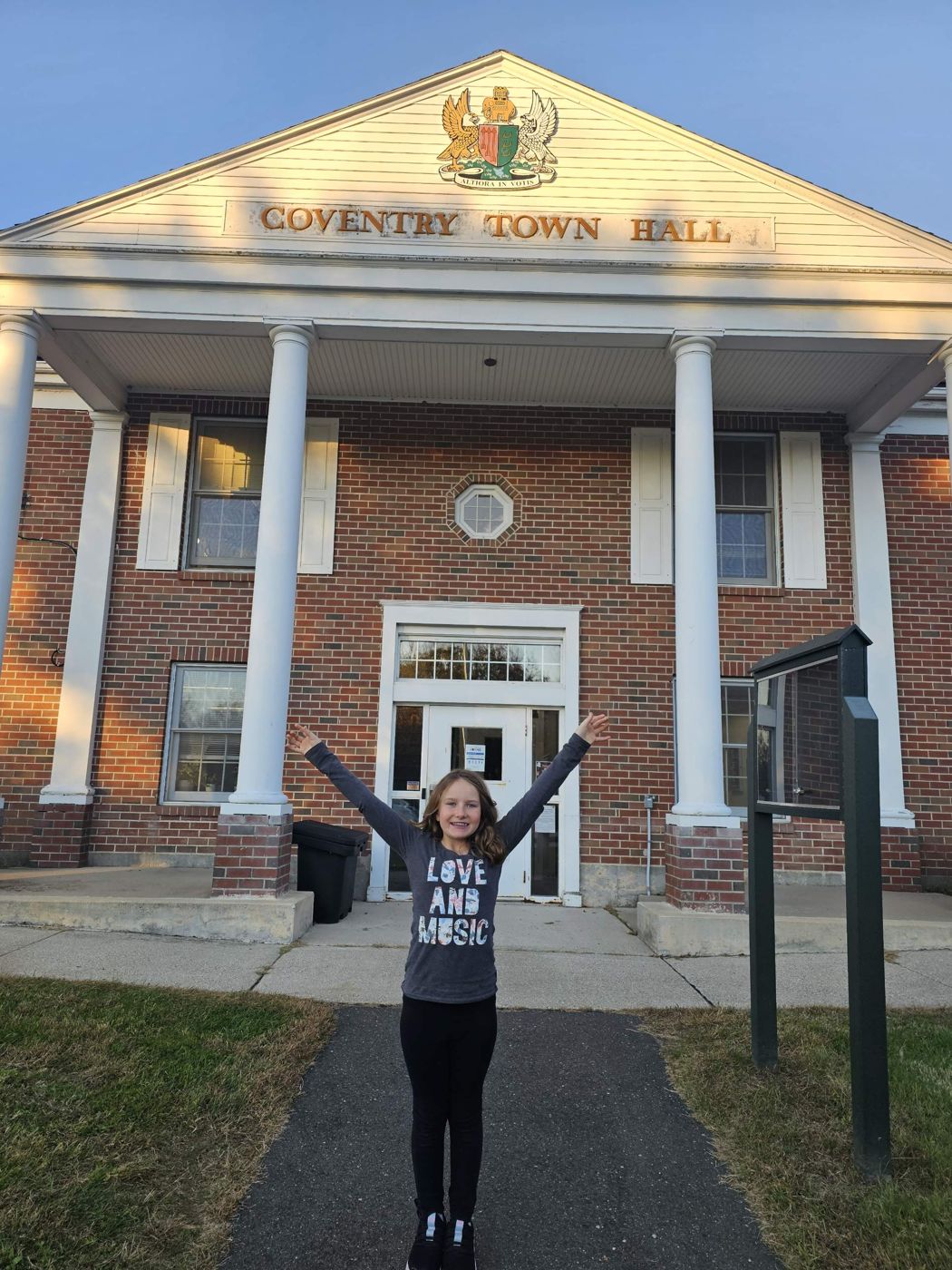 Adeline with her arms raised in front of Coventry Town Hall